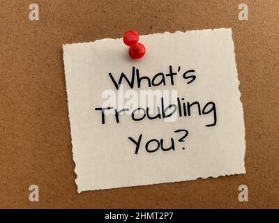 Cosa ti disturba il testo sul blocco note bianco. Foto Stock