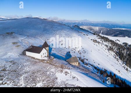 Vista aerea della cappella di Maria Schnee in Austria in una splendida giornata invernale Foto Stock