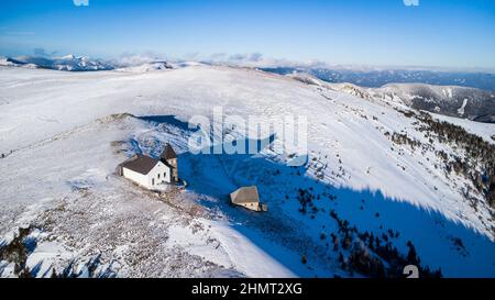 Vista aerea della cappella di Maria Schnee in Austria in una splendida giornata invernale Foto Stock