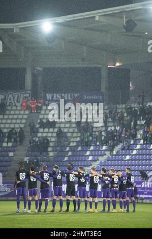 11 febbraio 2022, Sassonia, Aue: Calcio: 2nd Bundesliga, Erzgebirge Aue - Holstein Kiel, Matchday 22, a Erzgebirgsstadion. I giocatori di Erzgebirge Aue si alzano in campo prima della partita durante un minuto di silenzio per il defunto allenatore Gerd Schädlich. L'allenatore di promozione Aue dell'anno 2003 era morto la settimana scorsa all'età di 69 anni Foto: Sebastian Kahnert/dpa-Zentralbild/dpa - NOTA IMPORTANTE: In conformità con i requisiti della DFL Deutsche Fußball Liga e della DFB Deutscher Fußball-Bund, è vietato utilizzare o utilizzare fotografie scattate nello stadio e/o della partita sotto forma di seq Foto Stock