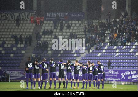 11 febbraio 2022, Sassonia, Aue: Calcio: 2nd Bundesliga, Erzgebirge Aue - Holstein Kiel, Matchday 22, a Erzgebirgsstadion. I giocatori di Erzgebirge Aue si alzano in campo prima della partita durante un minuto di silenzio per il defunto allenatore Gerd Schädlich. L'allenatore di promozione Aue dell'anno 2003 era morto la settimana scorsa all'età di 69 anni Foto: Sebastian Kahnert/dpa-Zentralbild/dpa - NOTA IMPORTANTE: In conformità con i requisiti della DFL Deutsche Fußball Liga e della DFB Deutscher Fußball-Bund, è vietato utilizzare o utilizzare fotografie scattate nello stadio e/o della partita sotto forma di seq Foto Stock