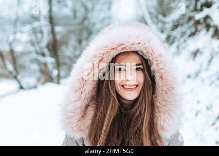 Ritratto all'aperto di una giovane donna in giacca invernale in pelliccia Foto Stock