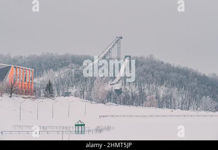 Piste o torri di salto con gli sci a Tatarstan, Russia. Rampe circondate da alberi innevati su una collina. Rampa di salto con gli sci Foto Stock