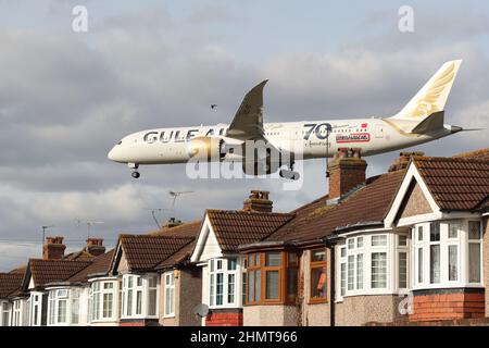 Un velivolo Gulf Air si avvicina all'aeroporto di Heathrow volando in basso sopra i tetti delle case in Myrtle Avenue, Londra, Regno Unito Foto Stock