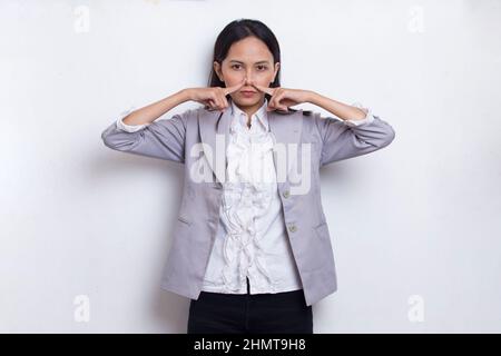 giovane donna asiatica bella che tiene il suo naso a causa di un cattivo odore qualcosa Foto Stock