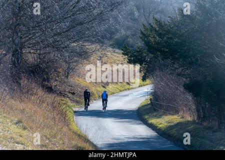 Coppia in bicicletta su Box Hill sulla Zig ZAG Road durante l'inverno, Surrey, Inghilterra, Regno Unito Foto Stock