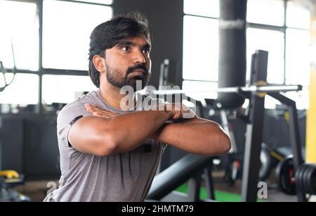 Medio primo piano colpo giovane atleta indiana facendo squats excerise in palestra - concetto di stile di vita sano, fitness e bodybuilding. Foto Stock