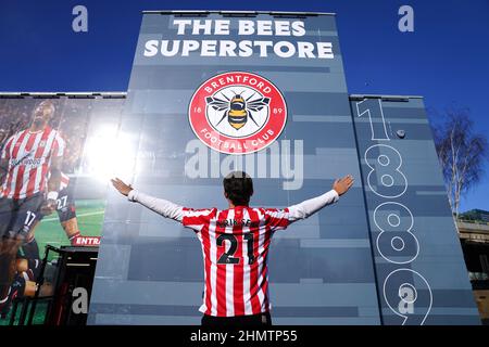 Un fan di Brentford che indossa una maglietta Christian Eriksen può scattare una foto fuori dal negozio prima della partita della Premier League al Brentford Community Stadium di Londra. Data foto: Sabato 12 febbraio 2022. Foto Stock