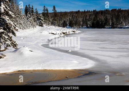 12 febbraio 2022, bassa Sassonia, Oderbrück: Parzialmente congelato, il bacino di Oderteich nel Parco Nazionale di Harz è alla luce del sole invernale sotto un cielo blu. (Al dpa 'tempo invernale nel Harz attrae escursionisti all'aperto - parcheggi completi') Foto: Moritz Frankenberg/dpa Foto Stock