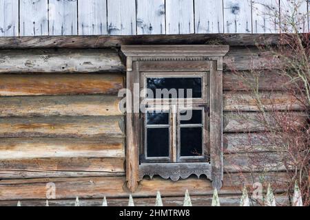 Casa rustica in legno di tronchi rotondi. Villaggi e case abbandonati. Antico design delle finestre. Foto Stock