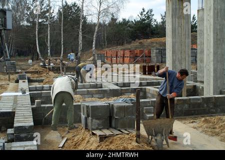 Ostrzeszów Polonia, Polen, Polska; lavoratori che lavorano sulle fondamenta dell'edificio.Arbeiter arbeiten an den Fundamenten des Gebäudes. Murarze murują Foto Stock