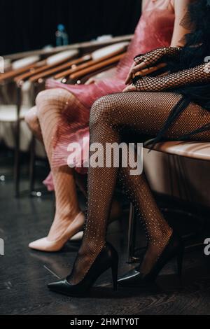 Gambe sottili femminili in eleganti collant in mesh e scarpe nere con tacco alto Foto Stock