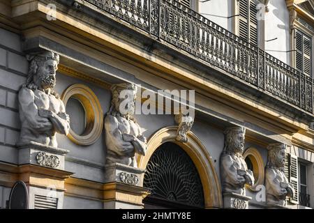 Facciata di un antico palazzo con telamoni di Ercole con la pelle del leone Nemeo ai lati della porta d'ingresso, Torino, Piemonte, Italia Foto Stock