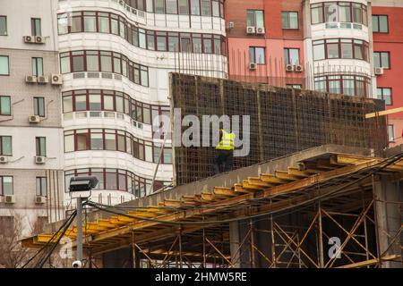 Cantiere. Il lavoratore esegue il lavoro in altezza. Foto Stock