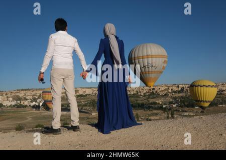 La coppia viaggia in tutto il mondo. Coppia felice e amorevole tra palloncini in Turchia. Coppia sposata in vacanza. Turisti in Cappadocia. Uomo e donna che riposano Foto Stock