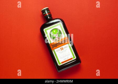 Ternopil, Ucraina - 24 maggio 2021: Una bottiglia di liquore Jagermeister su sfondo rosso vista dall'alto Foto Stock