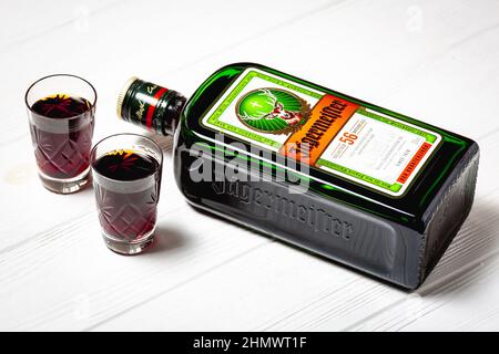 Ternopil, Ucraina - 24 maggio 2021: Una bottiglia di liquore Jagermeister e due bicchieri su sfondo bianco vista dall'alto Foto Stock