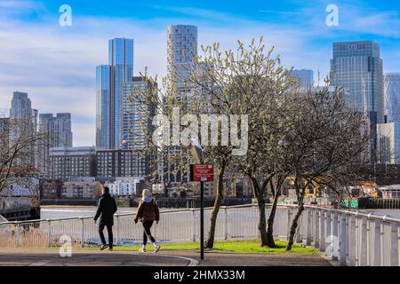 Londra, Regno Unito. 12th Feb 2022. La gente cammina e corre lungo il Tamigi alla Penisola di Greenwich con Canary Wharf sullo sfondo in una splendida giornata di sole a Londra. Credit: Imagplotter/Alamy Live News Foto Stock