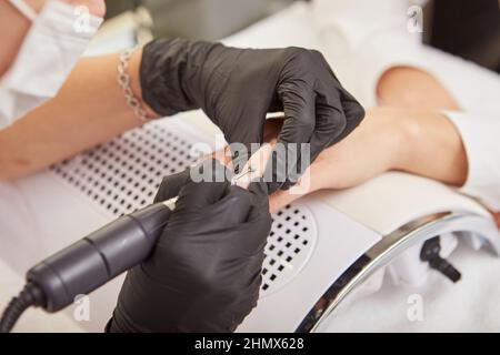 Manicurista che fa manicure per il cliente con la macchina elettrica del chiodo Foto Stock