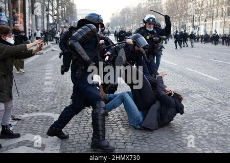I poliziotti francesi anti-sommossa si scontrano con un protester sugli Champs Elysees a Parigi vicino all'Arco di Trionfo il 12 febbraio 2022, quando convogli di manifestanti così chiamati convoi de la Liberte arrivarono nella capitale francese. Migliaia di manifestanti in convogli, ispirati dagli autotrasportatori canadesi che paralizzavano il traffico di frontiera con gli Stati Uniti, si sono recati a Parigi da tutta la Francia il 11 febbraio, con alcuni che speravano di bloccare la capitale in opposizione alle restrizioni del Covid-19 nonostante gli avvertimenti della polizia di tornare indietro. I manifestanti includono molti attivisti anti-vaccinali, ma anche persone che protestano contro la rapida risina Foto Stock