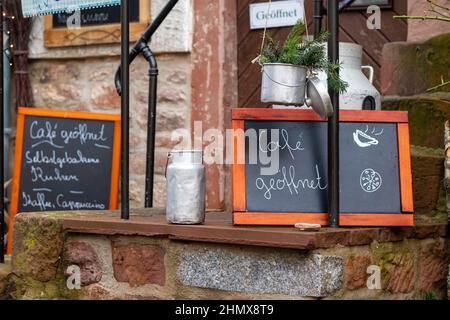 lavagna con il messaggio scritto a mano con le parole tedesche per caffè aperto di fronte ad un piccolo ristorante in una città vecchia tedesca. Foto Stock