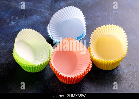 Casse vuote per cupcake, moduli su sfondo blu, tavolo. Foto Stock