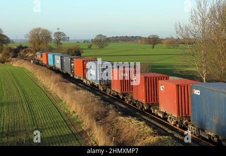 Treno merci intermodale per container che attraversa Staffordshire, Regno Unito, nel gennaio 2022. Foto Stock