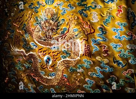 Un drago di un elaborato vestito di drago di seta giallo ricamato del 19th secolo dalla Cina in mostra al Chester Beatty Museum di Dublino, Irlanda Foto Stock