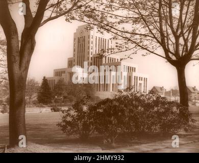 Fotografia di seppia vintage in bianco e nero ca. 1937 dell'edificio del Municipio di Vancouver in stile Art Deco incorniciato da alberi, Vancouver, British Columbia, Canada Foto Stock