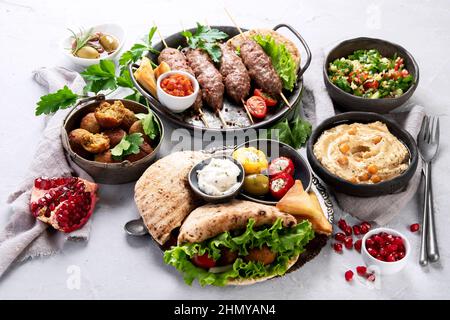 Assortimento di cibo libanese su sfondo chiaro. Concetto di cibo tradizionale. Foto Stock