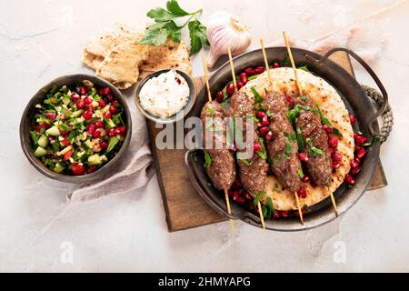 Kebab con pita su sfondo chiaro. Concetto di dieta mediterranea. Disposizione piatta, vista dall'alto Foto Stock