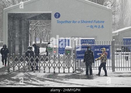 Pechino, Cina. 13th Feb 2022. Olimpiadi, caratteristica, Pechino 2022 Winter Olympics staff stand a un checkpoint con le parole ''insieme per un futuro condiviso' il motto per le Olimpiadi invernali 2022. Credit: Peter Kneffel/dpa/Alamy Live News Foto Stock