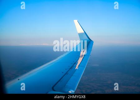 Voli economici, biglietti aerei biglietti aerei cielo blu brillante e nuvola fuori dalla finestra dell'aereo mentre volano alto sopra l'aria. Foto Stock