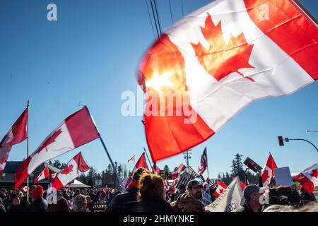 Vancouver, British Columbia, Canada. 12th Feb 2022. I manifestanti della Columbia Britannica si sono radunati contro i mandati COVID-19 provinciali e nazionali, poiché azioni simili scoppiano in tutto il paese. Migliaia di sostenitori si sono riuniti su 8th Avenue e sull'incrocio 176 Street Pacific Highway a Surrey per dare il benvenuto a un piccolo convoglio di veicoli di protesta che viaggiano dalla vicina Chilliwack al confine utilizzato principalmente dai camionisti. La polizia ha cercato di arrestare l'accesso dei manifestanti, ma le loro barricate sono state violate in diverse occasioni. I manifestanti pedoni alla fine seguirono senza ostacoli, bloccando la trincata Foto Stock