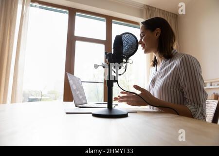 Una radio professionale sorridente che parla con il microfono del supporto. Foto Stock