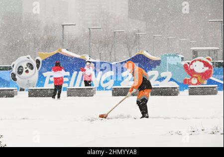 Pechino, Cina. 13th Feb 2022. Un operaio pulisce la neve fuori dal Centro principale dei mezzi di comunicazione delle Olimpiadi invernali di Pechino, capitale della Cina, 13 febbraio 2022. Credit: WU Wei/Xinhua/Alamy Live News Foto Stock