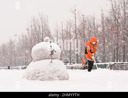 Pechino, Cina. 13th Feb 2022. I lavoratori puliscono la neve fuori dal Centro principale dei media delle Olimpiadi invernali di Pechino, capitale della Cina, 13 febbraio 2022. Credit: WU Wei/Xinhua/Alamy Live News Foto Stock