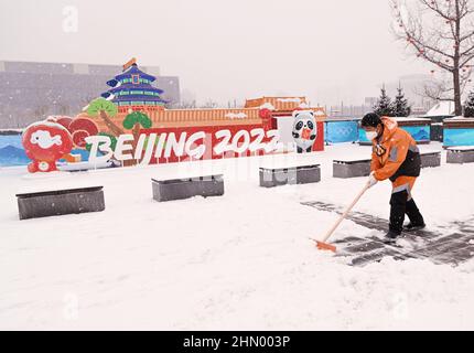 Pechino, Cina. 13th Feb 2022. Un operaio pulisce la neve fuori dal Centro principale dei mezzi di comunicazione delle Olimpiadi invernali di Pechino, capitale della Cina, 13 febbraio 2022. Credit: WU Wei/Xinhua/Alamy Live News Foto Stock
