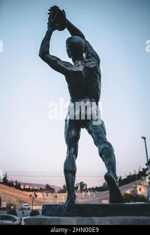 Colpo verticale della statua del lanciatore del disco olimpico greco ad Atene Foto Stock