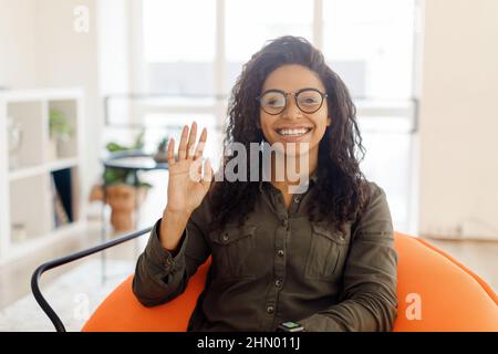 Concetto di saluto. Donna nera che ondita la mano alla macchina fotografica Foto Stock