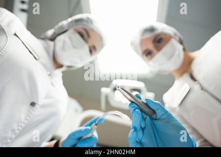 Dentista e assistente al lavoro. Punto di vista del paziente Foto Stock