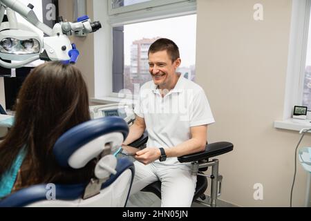 Il dentista comunica con il paziente negli studi dentistici utilizzando un tablet digitale Foto Stock