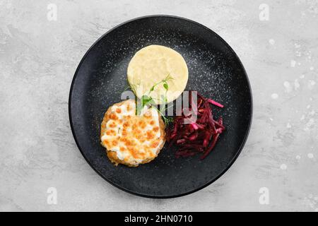 Città di Kiev con purè di patate e barbabietola sottaceto su un piatto, vista dall'alto Foto Stock