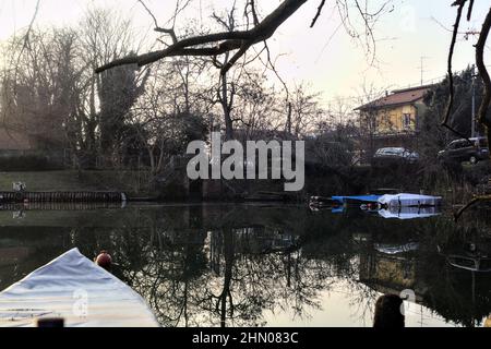 Insenatura di un fiume con barche in campagna al tramonto Foto Stock