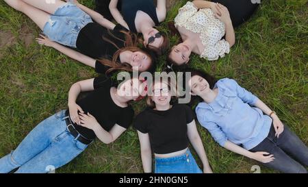 Le ragazze amiche giacciono sull'erba come un fiore. Foto Stock