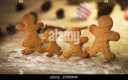 Uomini di pan di zenzero fatti sulla tavola di legno con gocce di gumdrop Foto Stock