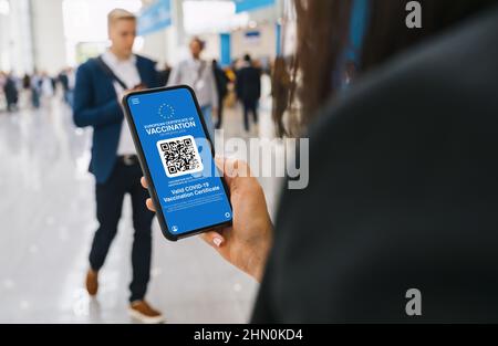 Europa Covid-19 Corona Pass certificato di immunità contro Covid19 su un telefono cellulare. Primo piano di una donna che dispone di un'applicazione per smartphone certi Foto Stock