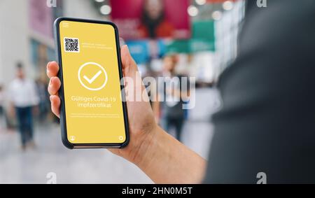 Gültiges Impfzertifikat (tedesco per: Certificato di vaccinazione valido per il covid-19 Corona Pass of Immunity contro Corona ) su un telefono cellulare. Foto Stock
