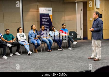 Educatore che istruisce diversi studenti adulti sulla finanza personale. Foto Stock