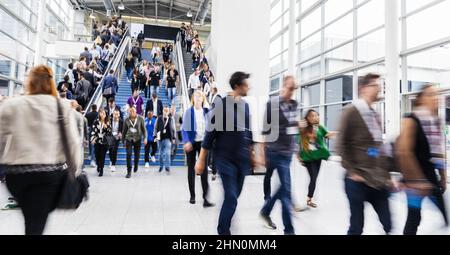 Molti anonimo la gente di affari su scala mobile a un business trade fair Foto Stock